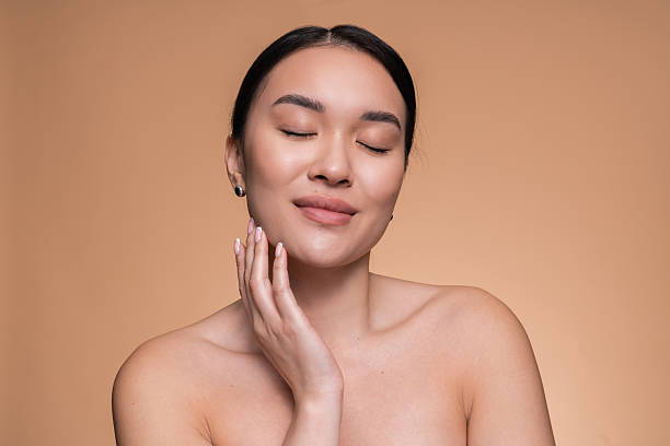 istock Serene Woman With Glowing Skin Posing Against Soft Peach Background 2208138534
