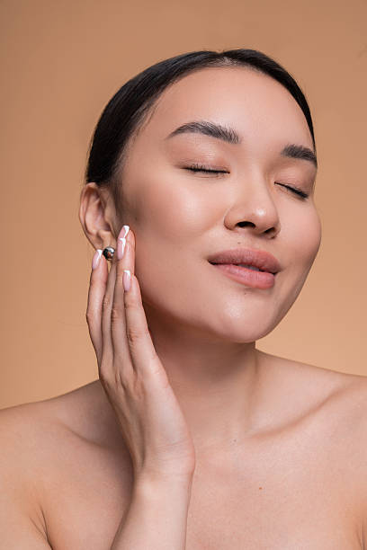 istock Relaxed Woman Enjoying Skincare Routine in Minimalistic Studio Setting 2208138796