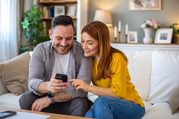 istock Couple enjoying looking photos on mobile phone 2208141395