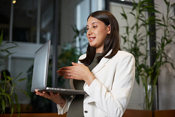 Professional Woman Presenting on a Laptop in a Modern Office
