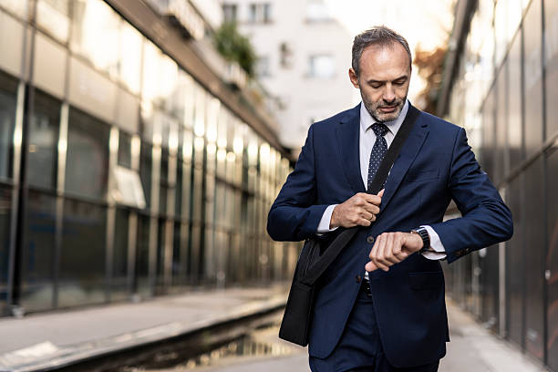 istock Businessman in a suit walking whilst checking his watch. 2208143967