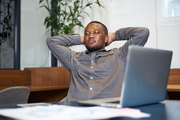 istock Relaxed Professional Taking a Break Silently in Office Setting with Laptop on Desk 2208146362