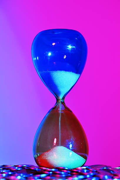 istock Hourglass with coins close up 2208146634