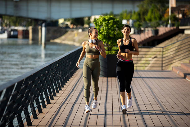 istock Female friends running together 2208154856