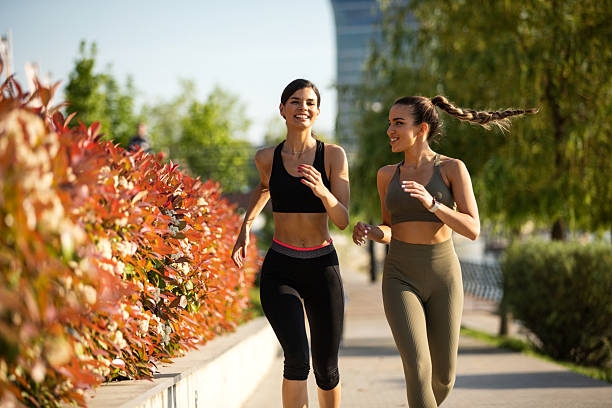 Best friends having fun together while running in the city urban road