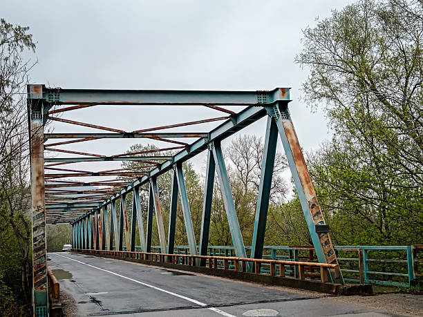 istock Lonely road across a rustic steel bridge 2208155257