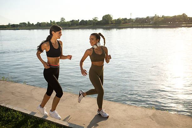 istock Female friends running together 2208155523