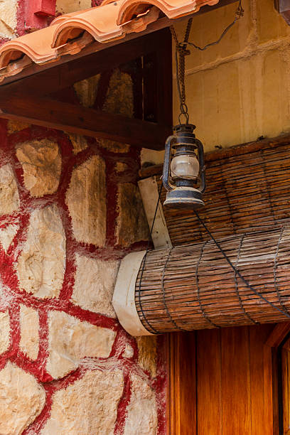 istock Rustic Lantern Hanging on Stone and Wood Building Exterior 2208157473
