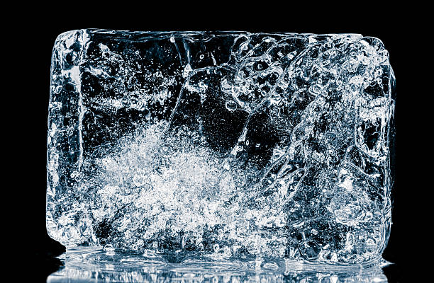 istock Natural textured ice block with cracks on a black reflective surface. 2208159178
