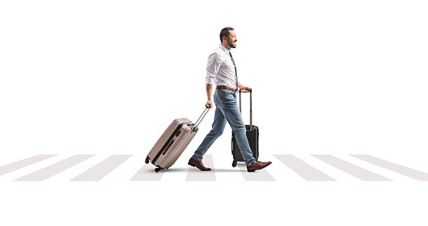 istock Man pulling suitcases and crossing a street 2208160249