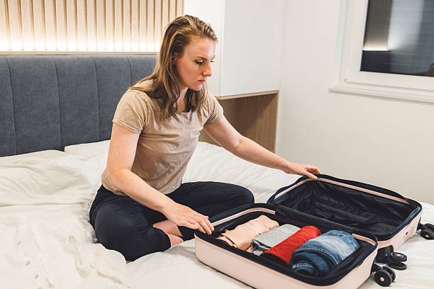 istock A young tourist carefully packs her suitcase in preparation for a weekend away. Space saving tricks for budget airline travel. 2208161794