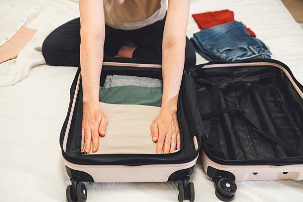 istock A young tourist carefully packs her suitcase in preparation for a weekend away. Space saving tricks for budget airline travel. 2208161797