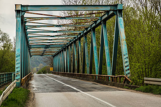 Steel trusses framing an empty road on a rural bridge
