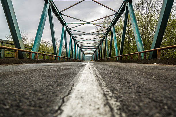 Steel trusses framing an empty road on a rural bridge
