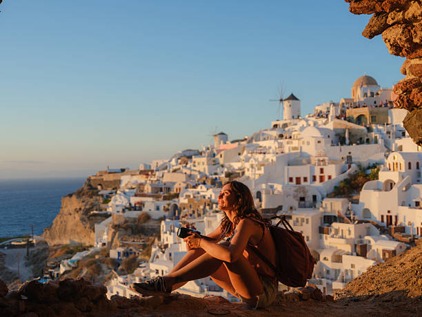 istock Woman with camera  looking with awe in Oia, Santorini 2208164199