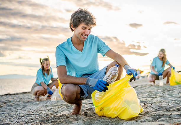istock Male volunteer cleaning a polluted beach 2208165261