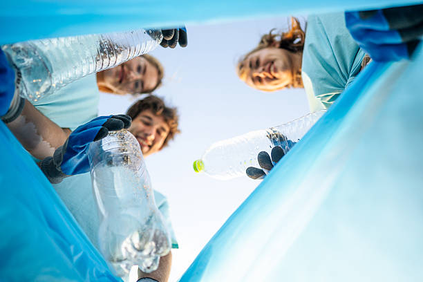 istock Volunteers putting plastic bottles in a trash bag 2208166138