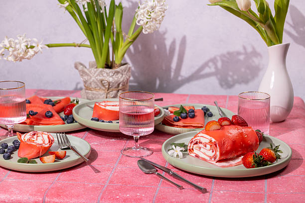 istock Pink strawberry dessert crepes and rolls served on table decorated with flowers 2208166344
