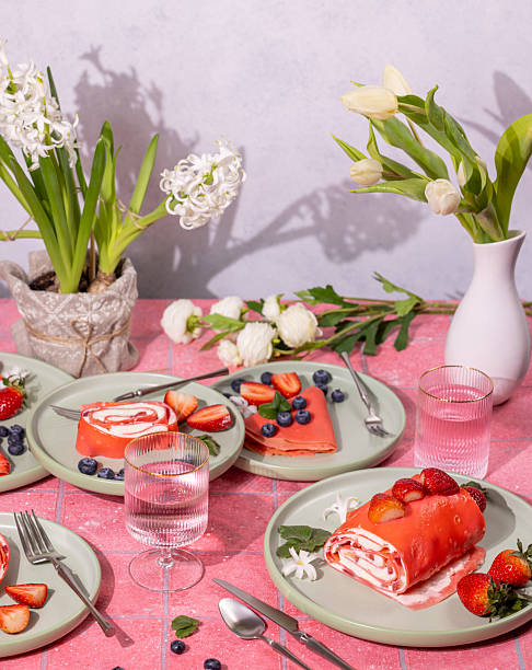 istock Pink strawberry crepe rolls served on plates with spring flowers 2208166546
