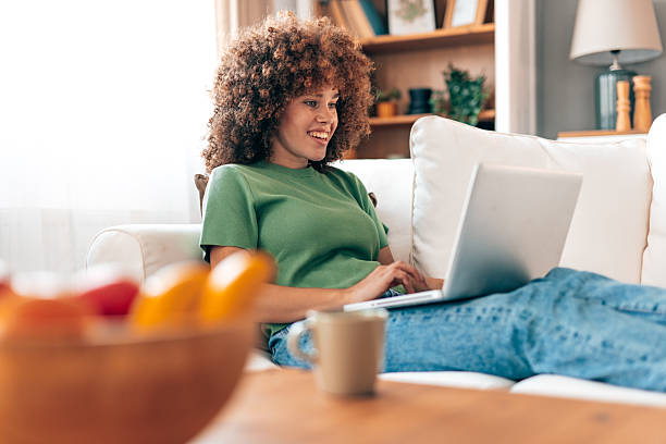 istock Young woman working from home lying on the sofa using laptop 2208167544