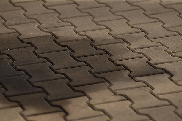 istock Close up of textured brick pavement with a shadow on it 2208167651