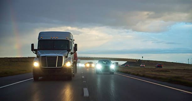 A semi-truck driving south on Interstate 5 in the Central Valley on a stormy evening.