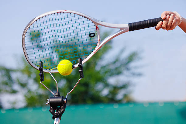 istock Tennis racket hitting ball on training tool, outdoor practice. 2208172986