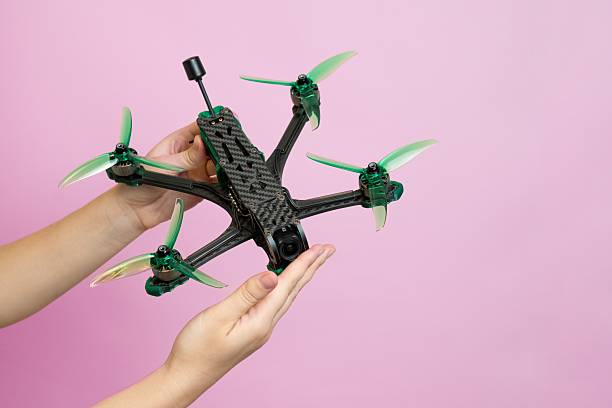 istock Hand holding modern drone with camera isolated on pink background 2208175079