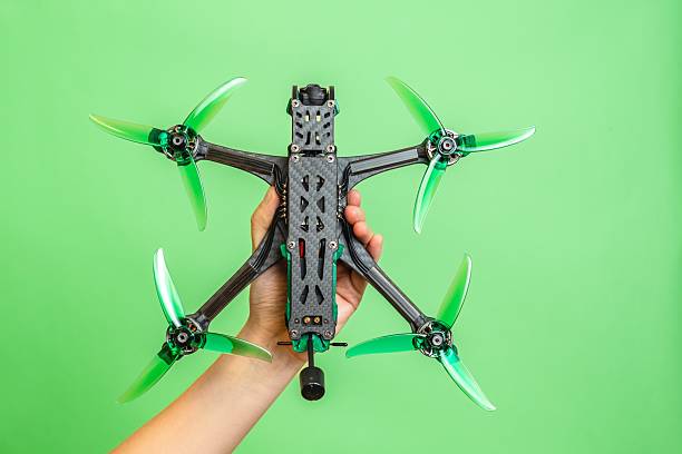 istock Hand holding professional modern drone with digital camera on green background 2208175091