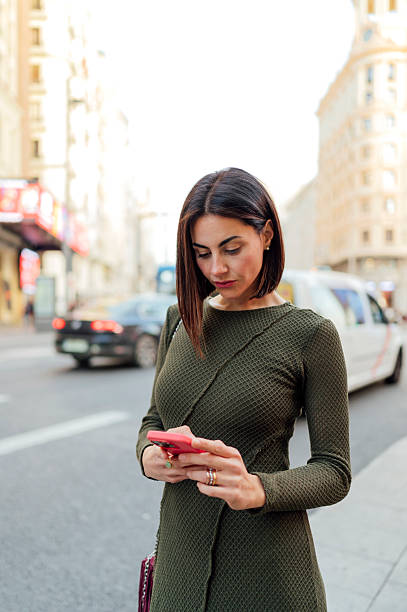 istock Businesswoman using smartphone while walking in city street 2208177004
