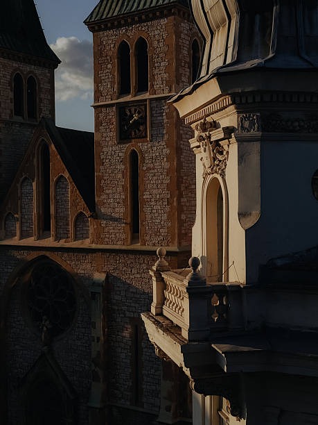 Sunlight illuminating the clock tower of the Sacred Heart Cathedral and the balcony of a nearby building in Sarajevo