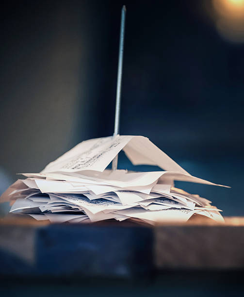 istock Stack of receipts piled up on a wooden table at a bustling cafe during morning hours 2208188532