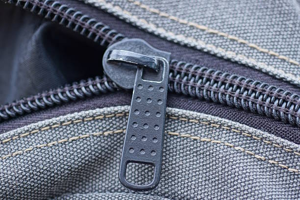 one black metal zip on the gray fabric of a large backpack