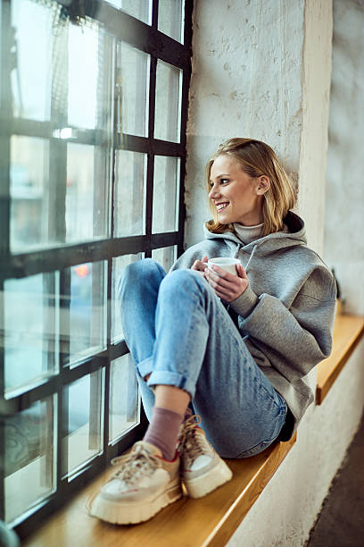 istock Casual Woman Enjoying Coffee By a Window in Relaxing Environment 2208190647