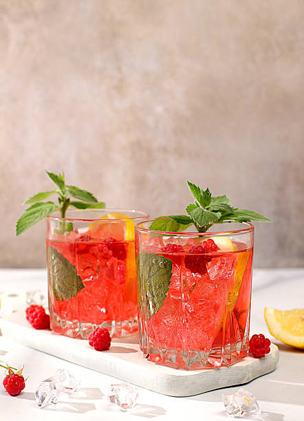 istock Cold homemade lemonade cocktail, mojito with mint, raspberry and fruits on a sunny table, refreshing summer drink recipe, detox diet and weight loss concept, restaurant menu 2208190927