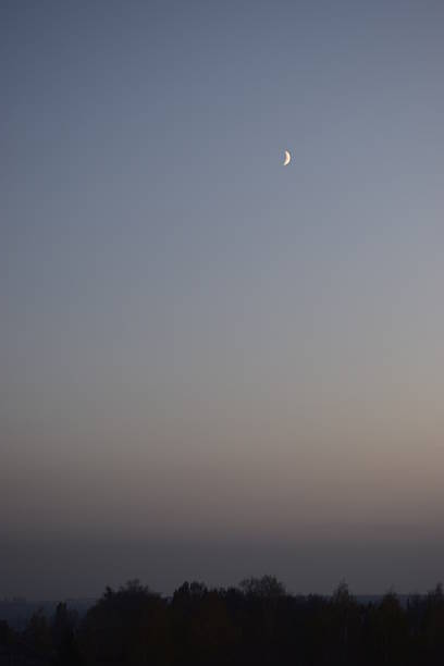 Half moon and beautiful sunset. Sunset over the city. Light in dark sky. Dramatic nature background