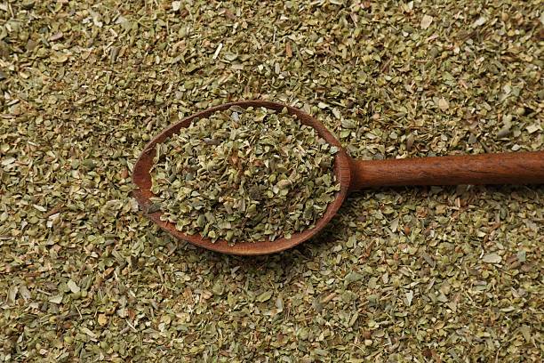 istock Dried oregano and wooden spoon, top view 2208194621