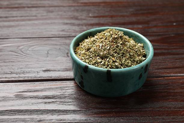 istock Dried oregano in bowl on wooden table, closeup. Space for text 2208194626
