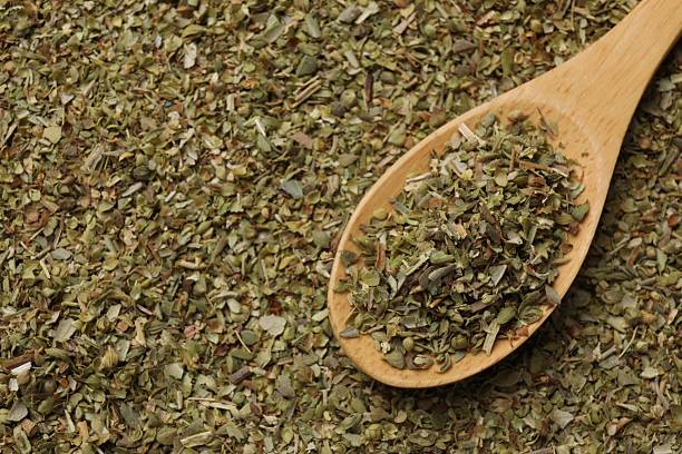 istock Dried oregano and wooden spoon, top view 2208194635