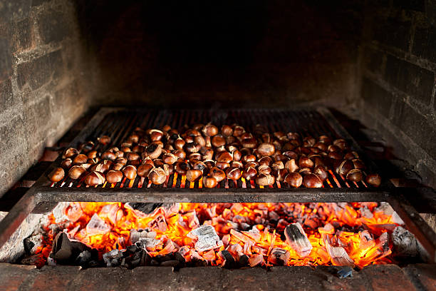 Brown chestnuts are roasted on hot coals on the grill. High quality photo