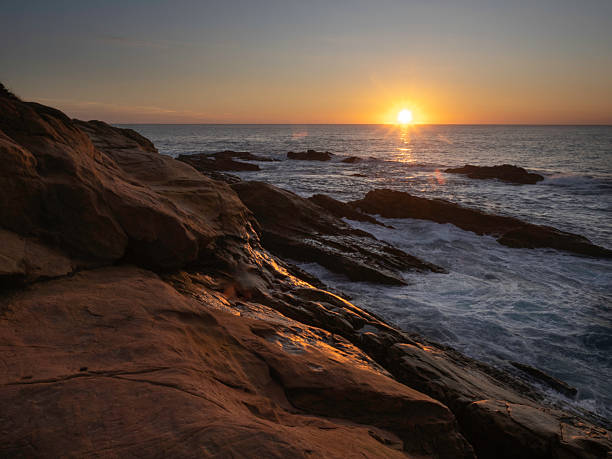 istock Sun rising over rocky coastline 2208200383