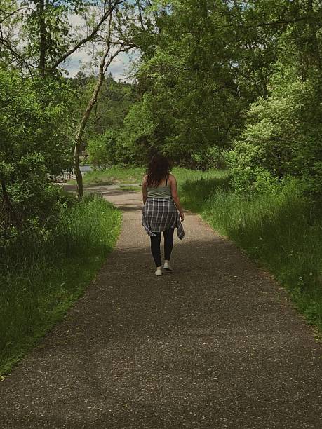 istock Young Woman Walking on a Forest Trail at park. 2208208534