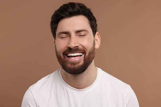 istock Handsome man laughing on light brown background, closeup 2208209185