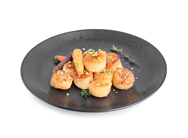 istock Delicious fried scallops with carrot and spices isolated on white 2208214196