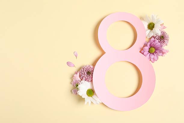 istock 8 March greeting card design with beautiful flowers on light yellow background, top view. Space for text 2208217257