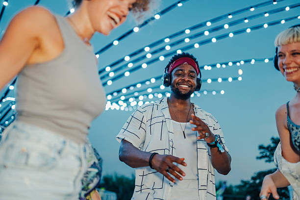 istock Friends enjoying music festival, dancing under string lights 2208219510
