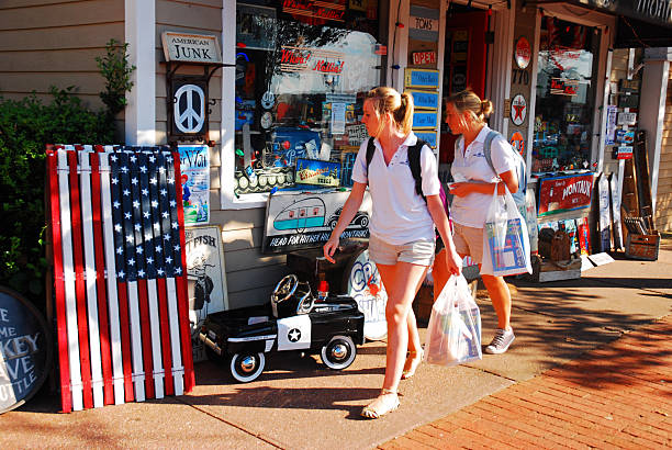 Montauk, NY, USA July 27, 2011 Two women friends walk through downtown Montauk New York, on Long Island, looking at an antique shop selling vintage art and toys