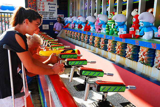 Pt Pleasant, NJ, USA September 10 A young woman in crutches plays the water gun balloon race on a summer day on the boardwalk in Pt Pleasant New Jersey, on the Jersey Shore