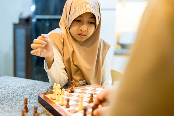 Senior man admiring precocious little kid lover chess board