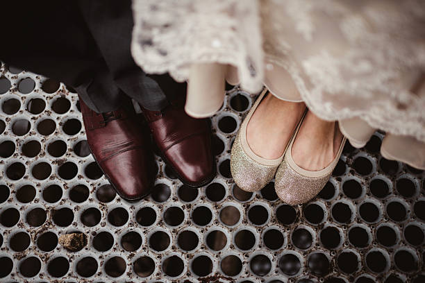 Bride and groom with focus on feet and shoes with geometric floor background